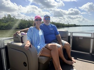 A couple enjoys a relaxing moment on a pontoon boat, surrounded by scenic waterways — perfect for leisurely outings and quality time together.