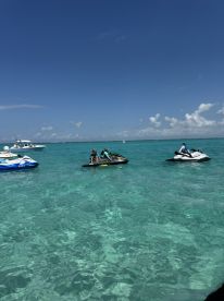 A group enjoys an exhilarating day on jet skis in crystal-clear waters, perfect for adventure seekers and water sports enthusiasts.
