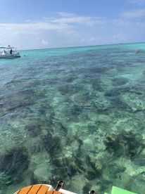 A picturesque view of turquoise waters with a boat in the background, perfect for swimming and enjoying the beautiful scenery.