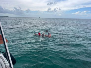 A group of snorkelers enjoys the vibrant waters, showcasing a fun and adventurous day on the water.
