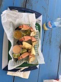 A delicious serving of crab claws with dipping sauce and lime, perfect for enjoying onboard or at a beachside picnic.