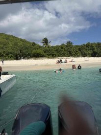 A lively scene at a beach with guests enjoying the water and sun, perfect for a sandbar stop during a boating adventure.