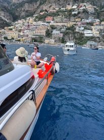 A group enjoys a scenic boat ride near the stunning coastline of Positano, capturing the essence of relaxation and adventure on the water.