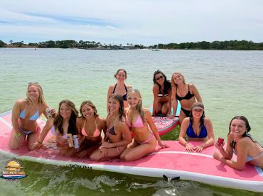 A fun group of friends enjoys a day on the water in Destin, Florida, relaxing on paddleboards and sipping drinks — perfect for summer celebrations and beach outings.