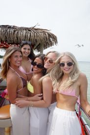 A joyful group of friends poses together on a boat, capturing the essence of fun and celebration on the water.