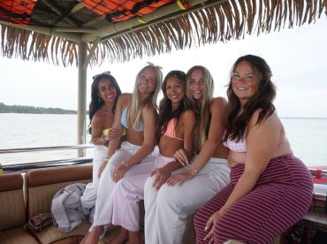 A cheerful group of friends enjoys a fun day on the boat, showcasing the perfect atmosphere for celebrations and memorable moments on the water.