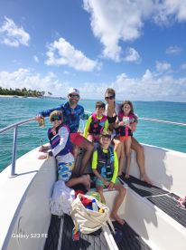 A joyful family poses on the deck of a boat, enjoying a sunny day on the water — perfect for creating unforgettable memories during summer adventures.