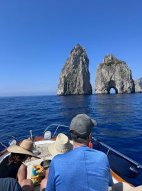A group of guests enjoys a scenic view of iconic rock formations from their boat, capturing the essence of a memorable day on the water.