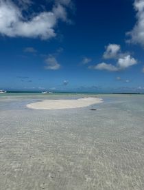A picturesque view of a sandbar with clear turquoise waters and a beautiful sky, perfect for beach outings and island adventures.