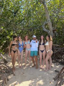 A lively group of friends poses together on the beach, enjoying their time in the sun — perfect for beach outings and memorable adventures.