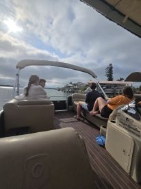 A group enjoys a relaxing day on a pontoon boat, taking in the scenic views along the waterway — perfect for family outings or gatherings with friends.