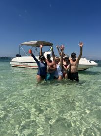 A lively group enjoys a fun day in the water, celebrating with drinks beside their boat, the 'Salt Dancer' — perfect for summer adventures and memorable outings.
