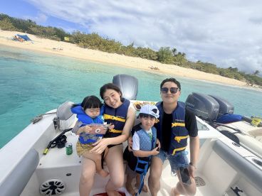 A joyful family enjoys a day on the boat, with children and beach scenery in the background — perfect for memorable family outings on the water.