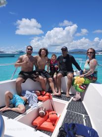 A joyful group of family and friends enjoying a sunny day on a boat, showcasing fun and relaxation in the beautiful turquoise waters.
