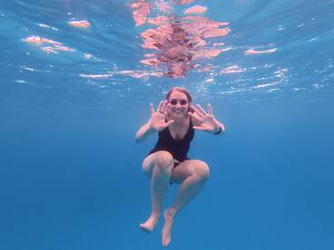 A joyful swimmer poses underwater, showcasing the fun and excitement of aquatic adventures — perfect for capturing memorable moments during a boat trip.