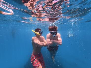 Two snorkelers explore the vibrant underwater world, showcasing the excitement of marine adventures. Perfect for highlighting snorkeling experiences on your next boating trip.