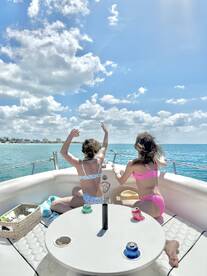Two young girls enjoy a fun day on the water, celebrating with drinks and laughter aboard a boat — a perfect moment for family adventures.