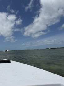 An unclear view from a boat, capturing the sky and water but lacking a distinct subject or focus.