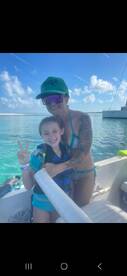 A joyful moment captured with a woman and a child on a boat, both smiling and enjoying their time on the water — perfect for family adventures and memorable outings.