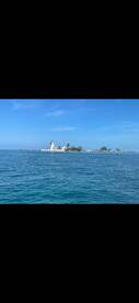 A picturesque view of a serene island with a lighthouse, surrounded by clear blue waters — an ideal destination for boat tours and scenic cruises.