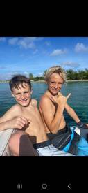 Two boys enjoy a sunny day on a boat, showcasing their excitement and camaraderie — perfect for capturing fun moments on the water.