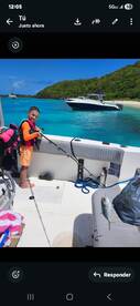 A young boy proudly holds a fishing rod on a boat, showcasing his catch against a stunning turquoise ocean backdrop — a perfect family fishing adventure.