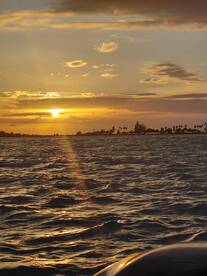 A stunning sunset over the water, capturing the serene beauty of the evening sky — perfect for romantic boat cruises or peaceful reflections on the water.