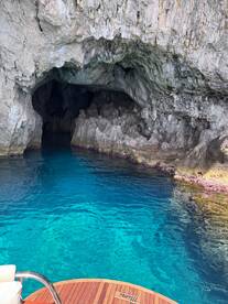 A stunning view of a cave entrance surrounded by crystal-clear turquoise waters, perfect for exploring hidden gems along the coastline.