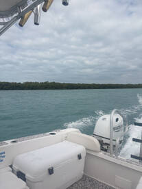 Interior view of a boat showcasing seating and a cooler, perfect for a day out on the water.