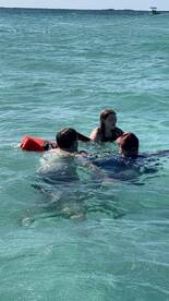 A group enjoys a fun water activity in the clear turquoise waters, showcasing the excitement of a day on the water.