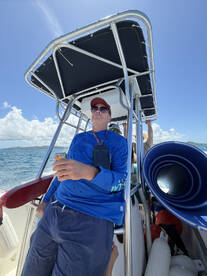A man enjoys a drink while seated at the helm of a boat, showcasing the comfortable interior space ideal for relaxing on the water.