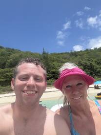 A cheerful couple enjoys a sunny day at the beach, capturing a memorable moment in paradise — perfect for summer getaways and romantic escapes.