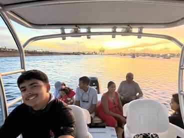 A joyful family enjoys a scenic boat ride at sunset, capturing the essence of togetherness and adventure on the water.
