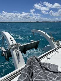 A close-up view of a catamaran's deck with the turquoise waters in the background, showcasing the vessel's structure and the serene boating experience.