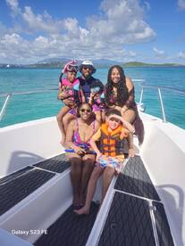 A joyful family poses on a boat, ready for a snorkeling adventure in crystal-clear waters, capturing the essence of fun and togetherness on the water.