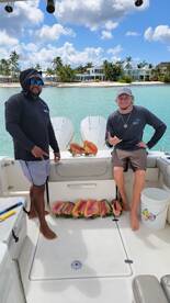 Two fishermen proudly display their catch aboard a boat, showcasing a successful day on the water. Perfect for fishing enthusiasts and adventure seekers.
