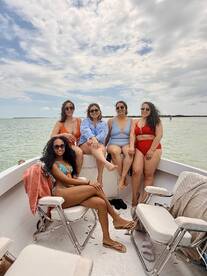 A fun group of friends relaxes on a boat, enjoying the sun and water — perfect for a day of celebration and camaraderie.