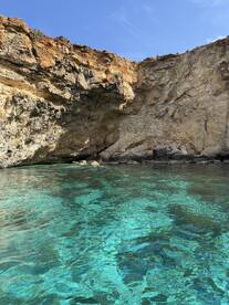 A stunning view of a rocky coastline with crystal-clear waters, perfect for exploring hidden coves and enjoying the beauty of nature.