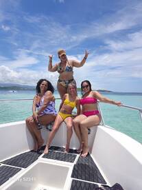 A lively group of friends poses on the deck of a boat, enjoying a sunny day on the water — perfect for celebrations and fun outings.