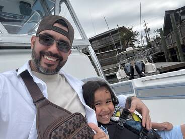 A joyful moment captured with a smiling adult and child aboard a boat, showcasing the fun and excitement of family time on the water.