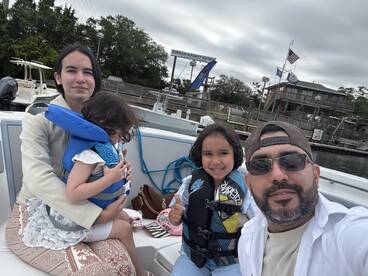 A family enjoys a day on the boat, with children wearing life jackets, capturing a fun and safe boating experience.