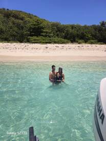 A joyful family enjoys a refreshing swim in crystal-clear waters, creating lasting memories on a beautiful beach day.