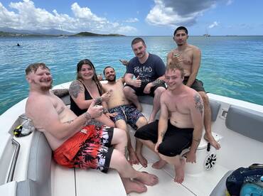 A lively group of friends enjoys a fun day on the boat, showcasing camaraderie and relaxation in the beautiful waters.