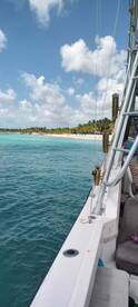 A scenic view from a boat showcasing a beautiful beach and turquoise waters, perfect for a day of relaxation and exploration.