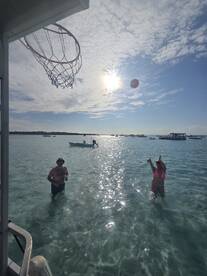 A fun day in the water with friends playing basketball under the sun, showcasing the perfect blend of relaxation and activity during a boating trip.