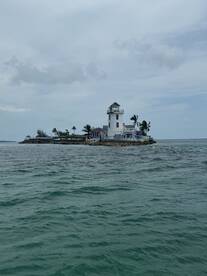 A picturesque view of a lighthouse on a small island, surrounded by tranquil waters — a perfect destination for scenic boat tours.