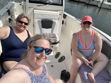 Three friends enjoy a sunny day on a Robalo boat, capturing a fun moment together while relaxing on the water.