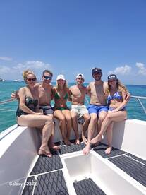 A cheerful group of friends enjoys a sunny day on the boat, perfect for celebrations and memorable outings on the water.