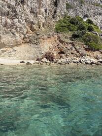 A stunning view of a rocky coastline with crystal-clear waters, perfect for exploring hidden beaches and enjoying nature's beauty.