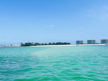 A stunning view of a tranquil coastline with clear turquoise waters and sandy beaches, perfect for a relaxing day on the water.